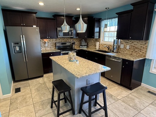 kitchen with light tile patterned floors, stainless steel appliances, visible vents, decorative backsplash, and a sink