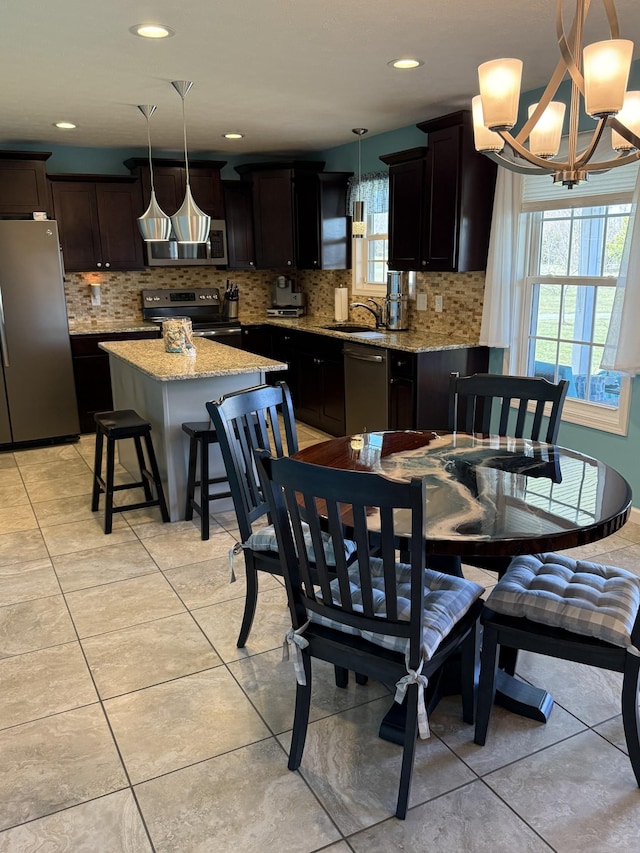 dining area with a healthy amount of sunlight, light tile patterned floors, and an inviting chandelier