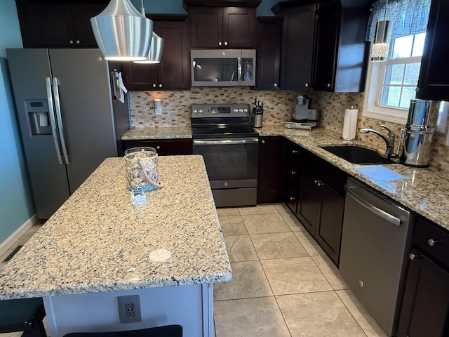 kitchen featuring light stone counters, light tile patterned floors, stainless steel appliances, backsplash, and a sink