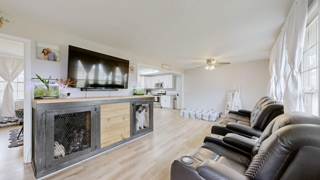 living area featuring light wood-type flooring and a ceiling fan