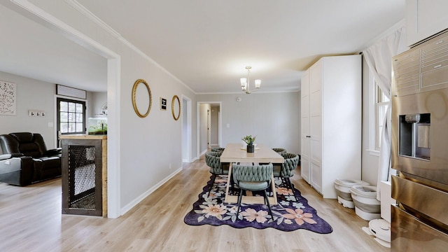 dining area featuring light wood-style floors, a chandelier, ornamental molding, and baseboards