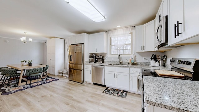 kitchen with stainless steel appliances, light wood-type flooring, white cabinetry, and a sink