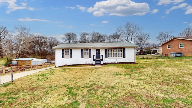 ranch-style house with fence, metal roof, and a front yard