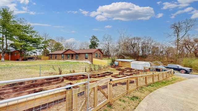 view of front facade featuring an outbuilding, a front lawn, fence, and a garden