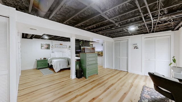 interior space featuring visible vents, two closets, and wood finished floors