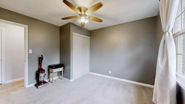 carpeted bedroom featuring a closet, baseboards, and a ceiling fan