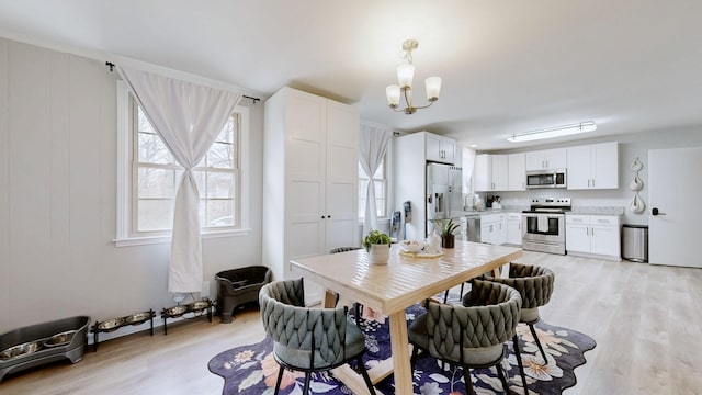 dining room with light wood-style flooring and a chandelier