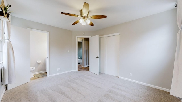 unfurnished bedroom featuring baseboards, ceiling fan, ensuite bathroom, carpet, and a closet