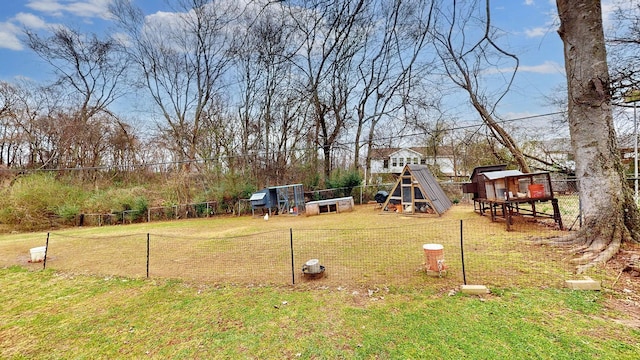 view of yard featuring an outdoor structure, fence, and exterior structure