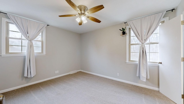 carpeted empty room featuring ceiling fan and baseboards