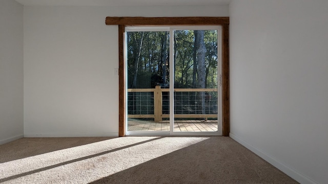 spare room featuring carpet and baseboards