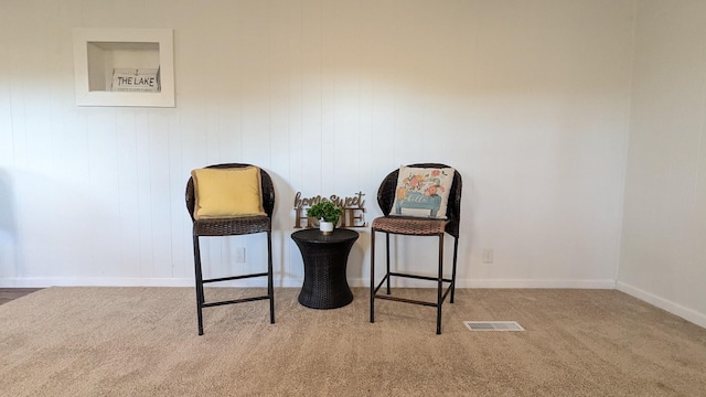 living area with carpet floors, visible vents, and baseboards