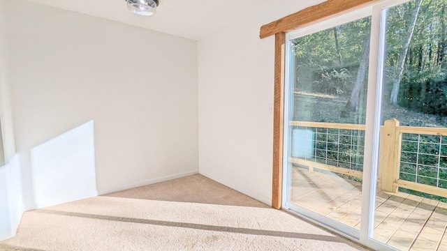 doorway to outside with carpet and baseboards