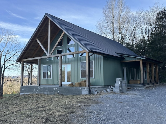 view of front of house with board and batten siding, french doors, and metal roof