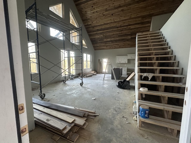 misc room with stairs and high vaulted ceiling