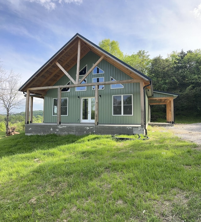 view of front of property with a front lawn, board and batten siding, and french doors