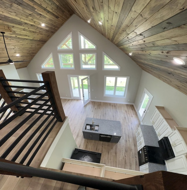 living area featuring high vaulted ceiling, wood finished floors, baseboards, and wood ceiling