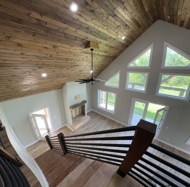 stairway featuring wood ceiling, ceiling fan, baseboards, and wood finished floors