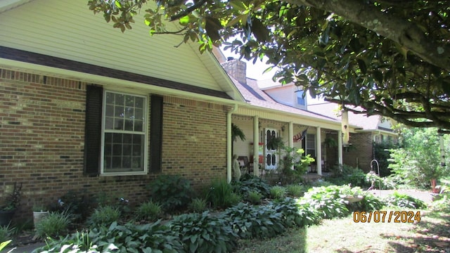 exterior space featuring brick siding and a chimney