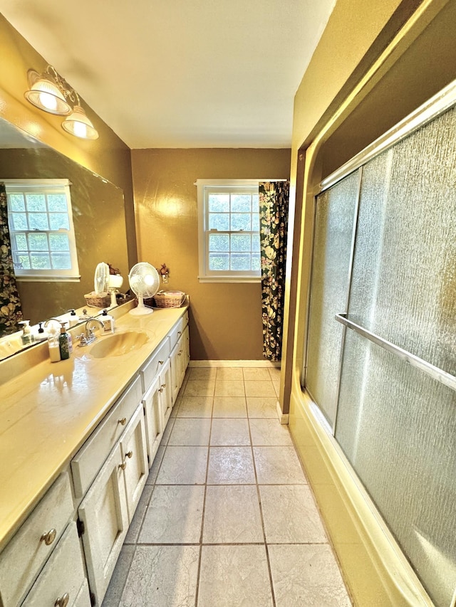 full bath featuring vanity, tile patterned floors, an enclosed shower, and baseboards