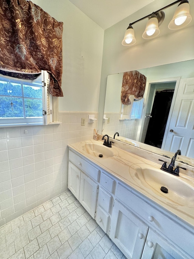 bathroom with double vanity, tile walls, and a sink