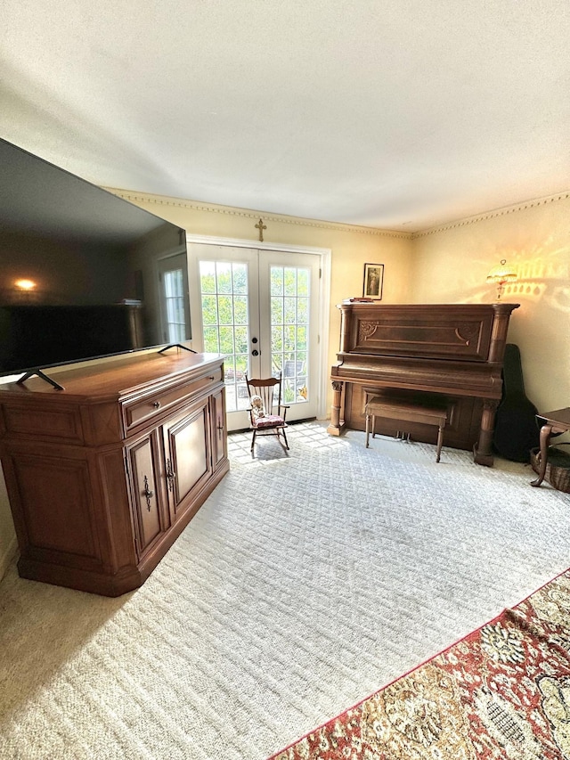 sitting room with french doors, light carpet, and a textured ceiling