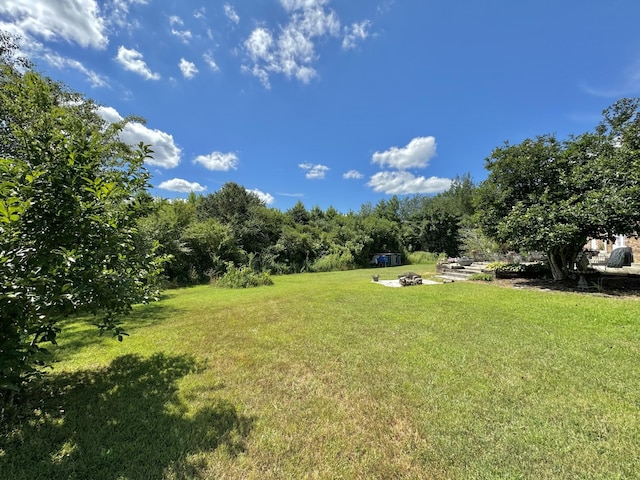 view of yard featuring an outdoor fire pit