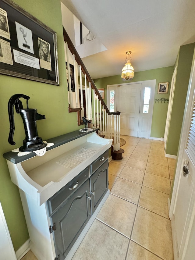 entrance foyer featuring stairs, light tile patterned flooring, and baseboards