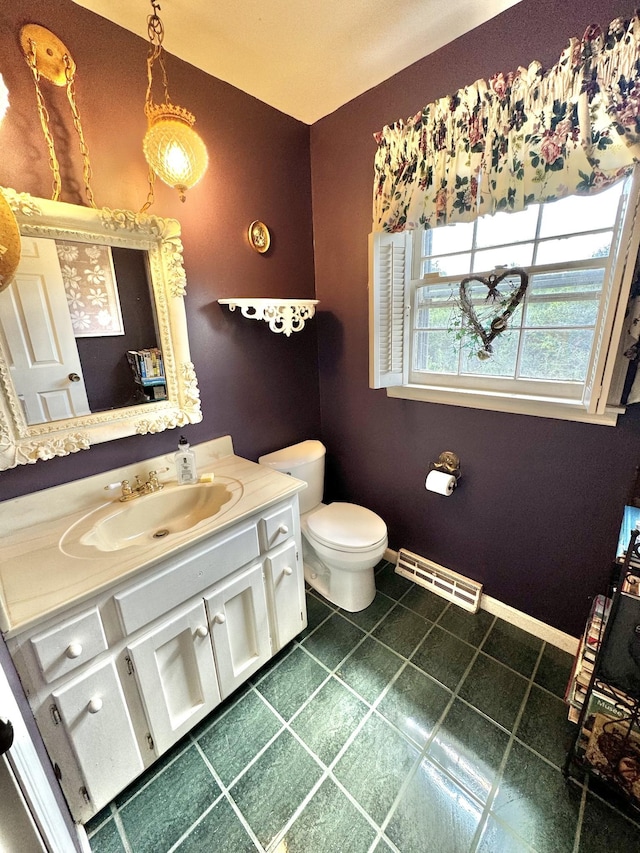 bathroom featuring vanity, baseboards, visible vents, tile patterned floors, and toilet