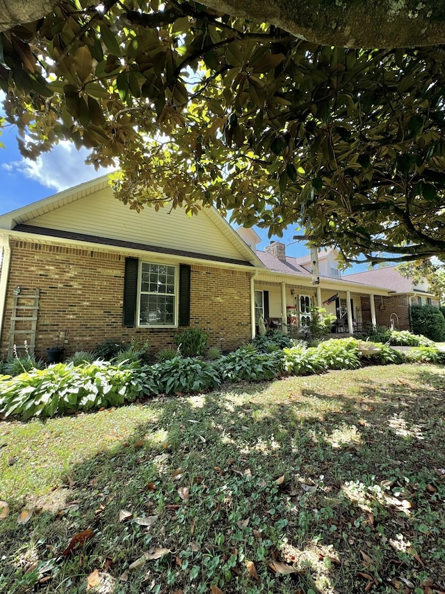 view of front of house with brick siding and a chimney