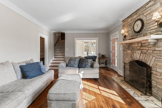 living room with a fireplace, hardwood / wood-style floors, stairs, and ornamental molding