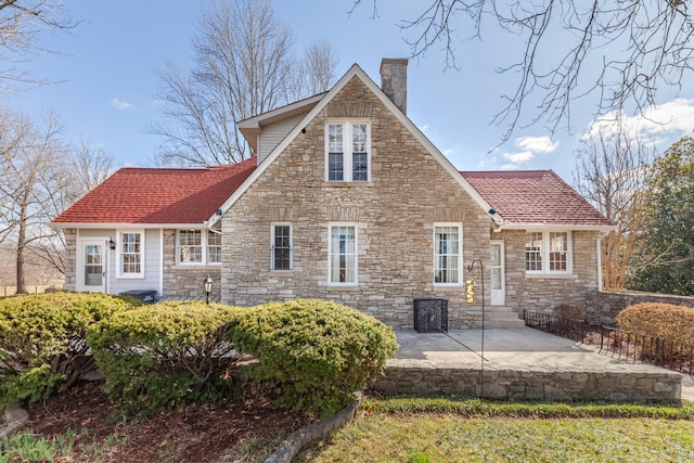 rear view of house with a patio area and a chimney