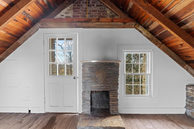 unfurnished living room with wood-type flooring, vaulted ceiling with beams, wooden ceiling, and a fireplace