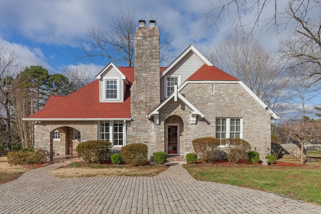 view of front of home with covered porch, a chimney, and a front lawn