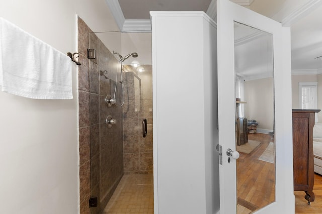 full bathroom with a shower stall, wood finished floors, and ornamental molding