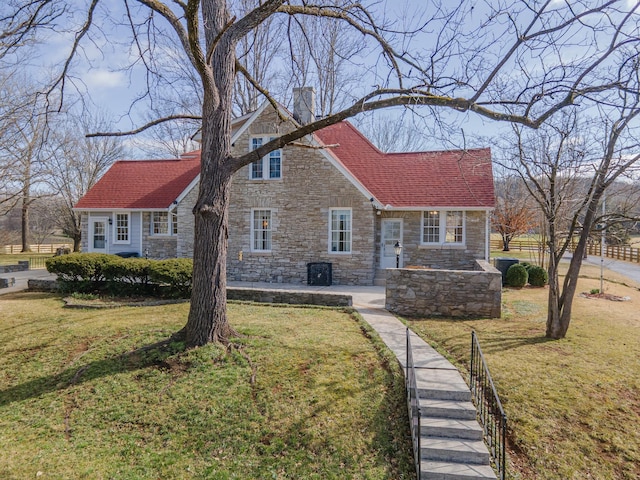 view of front of property with a chimney, a front lawn, and a shingled roof