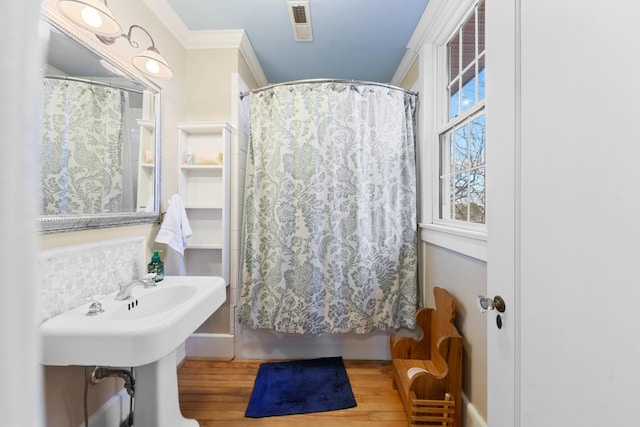 bathroom featuring visible vents, curtained shower, wood finished floors, and crown molding