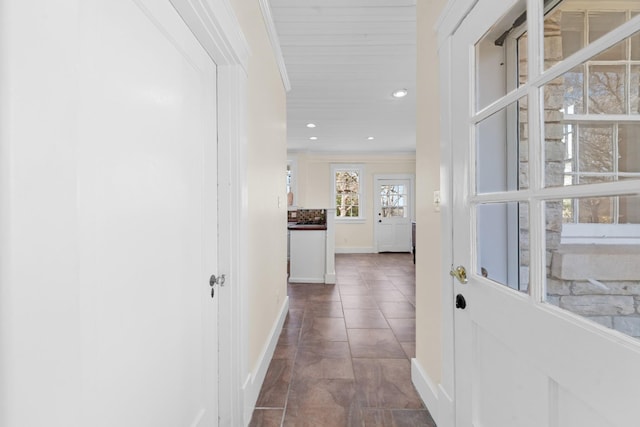 hallway with tile patterned flooring, recessed lighting, baseboards, and ornamental molding