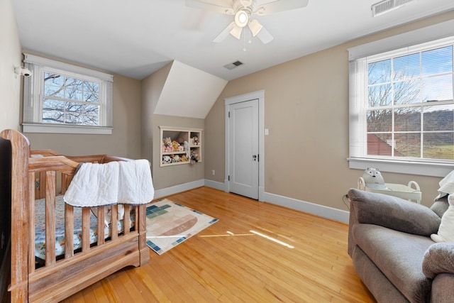 bedroom with light wood finished floors, visible vents, a ceiling fan, and baseboards