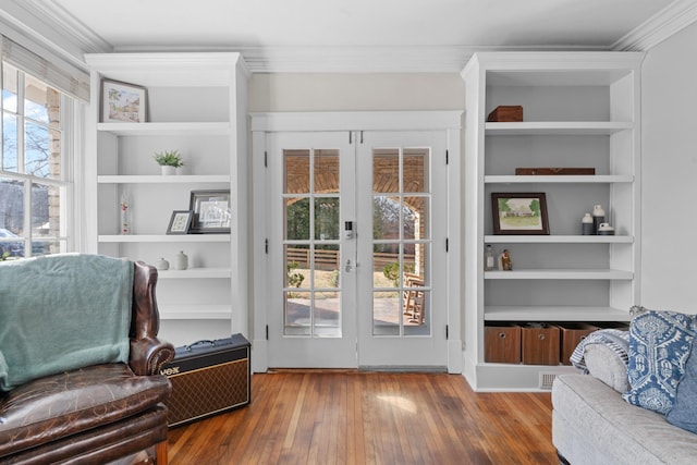 interior space with built in features, french doors, wood-type flooring, and ornamental molding