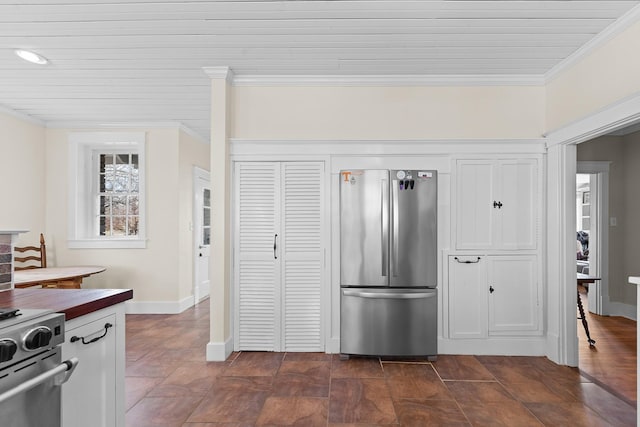 kitchen featuring stainless steel appliances, crown molding, and baseboards