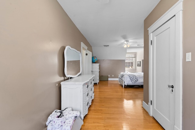 bedroom featuring light wood-type flooring, baseboards, visible vents, and ceiling fan