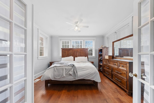 bedroom featuring dark wood finished floors, crown molding, and baseboards