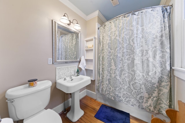 bathroom with visible vents, toilet, a shower with curtain, ornamental molding, and wood finished floors