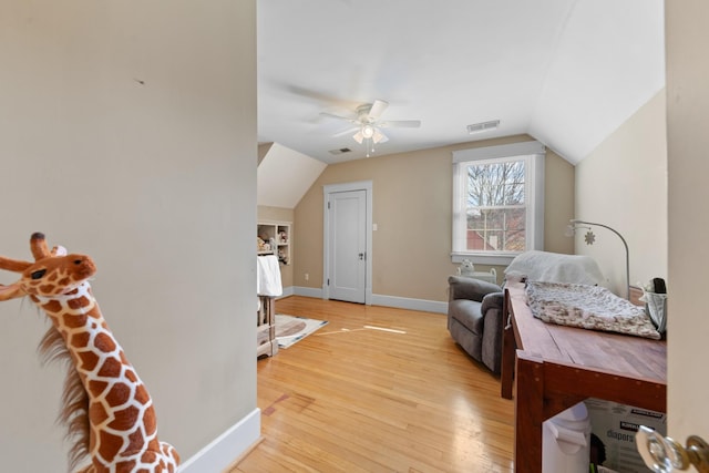 bedroom with vaulted ceiling, light wood-style flooring, baseboards, and visible vents