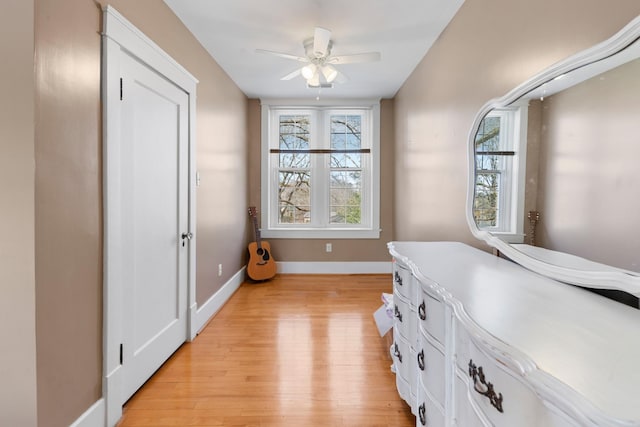 interior space featuring light wood finished floors, ceiling fan, and baseboards