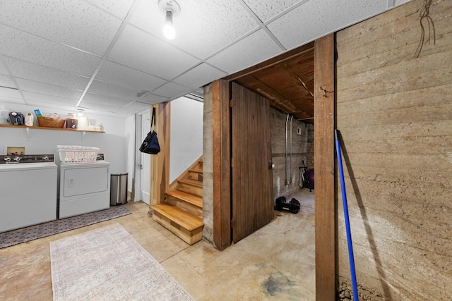 finished basement featuring washer and dryer, stairs, and a drop ceiling