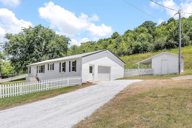 manufactured / mobile home featuring a front lawn, a fenced front yard, gravel driveway, a garage, and brick siding