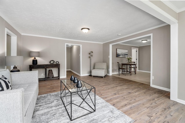 living room featuring crown molding, wood finished floors, and baseboards