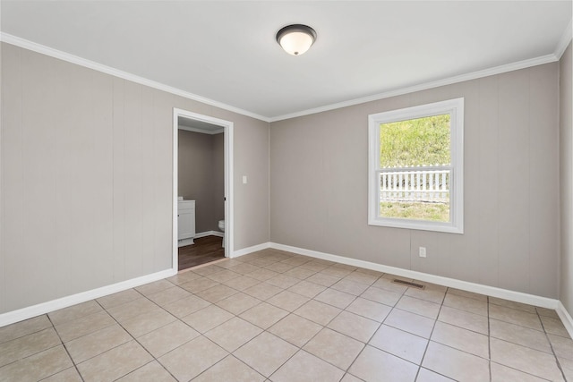 unfurnished room featuring baseboards, visible vents, and ornamental molding